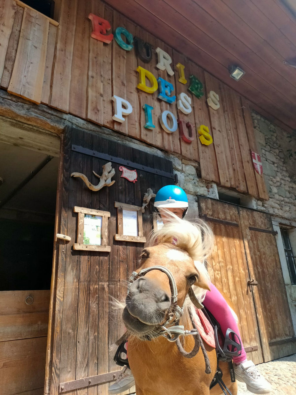 Séance à poney devant l'entrée des Écuries des Pious